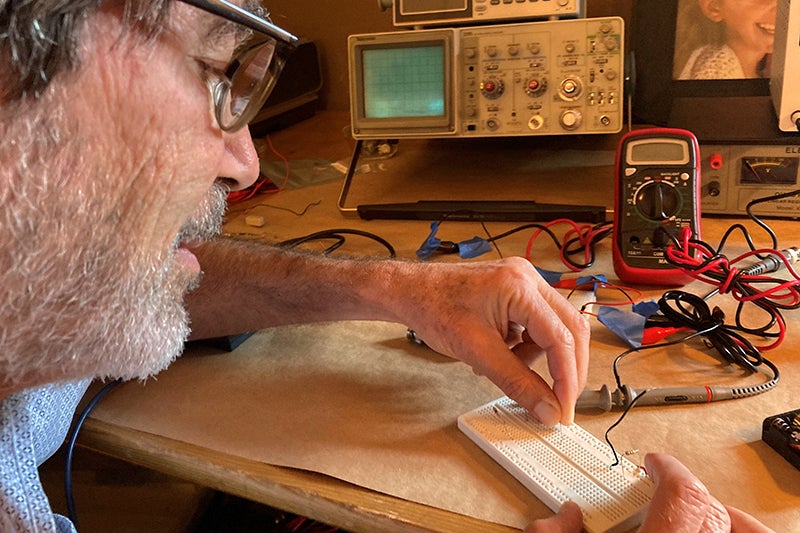 USC Professor Jack Feinberg uses a physics kit to build circuits for an online class in electricity and magnetism.