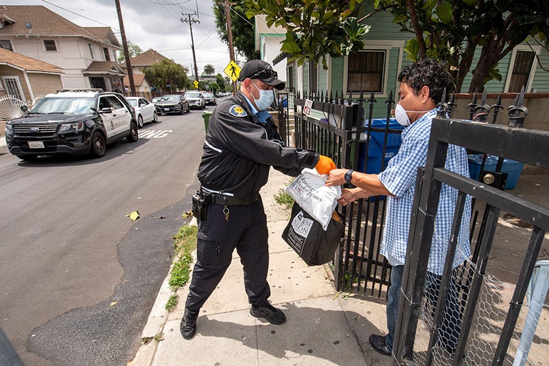 Jasser Cepeda, left, delivers food and books to local resident Alex DeLeon