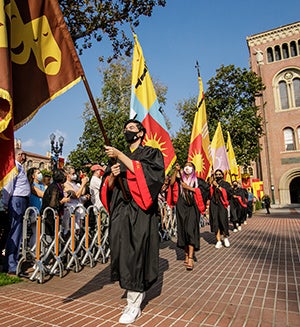 USC school flags paraded near Bovard during Convocation 2021.
