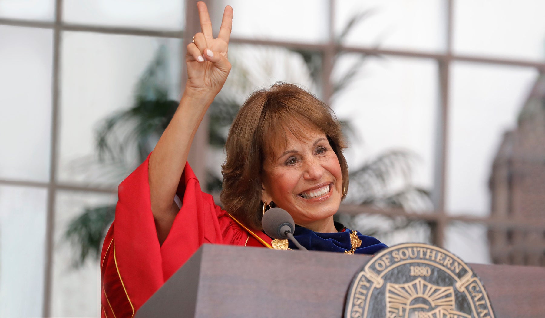 Carol Folt shows the victory sign to the crowd during commencement