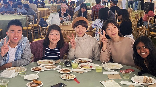 A group of USC students pose for a camera during a Thanksgiving meal