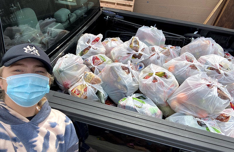 USC student Michel Faliski in front of a truckload of food delivery