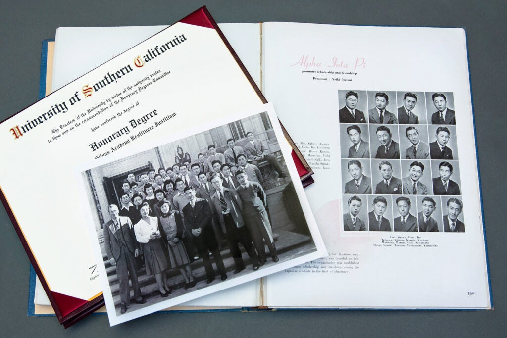 A yearbook and diploma with images of Nisei students