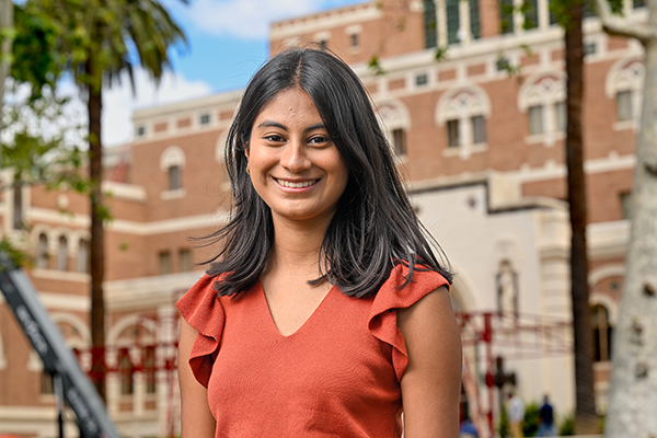USC 2023 valedictorian Isha Sanghvi poses for a photo in front of Doheny Library on campus.
