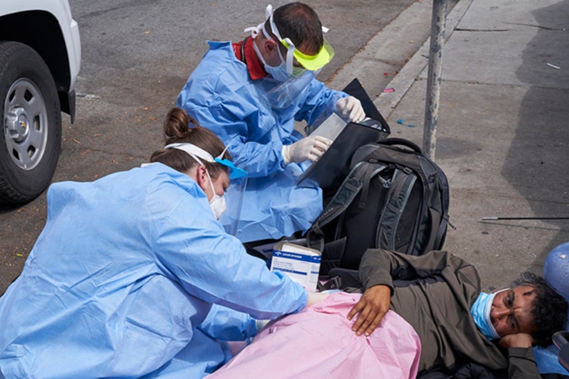 Photo of street medicine team helping out a patient