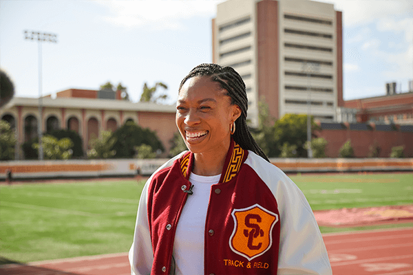 USC alumna and Olympian Allyson Felix stands smiling on the new USC track and field renamed Allyson Felix Field.