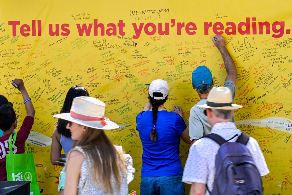 Photo of LA Times Festival of Books attendees writing what books they are reading on a poster