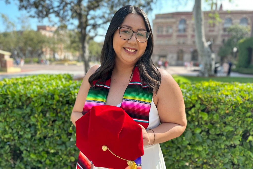 Photo of Latina doctoral candidate at USC with cap and sash