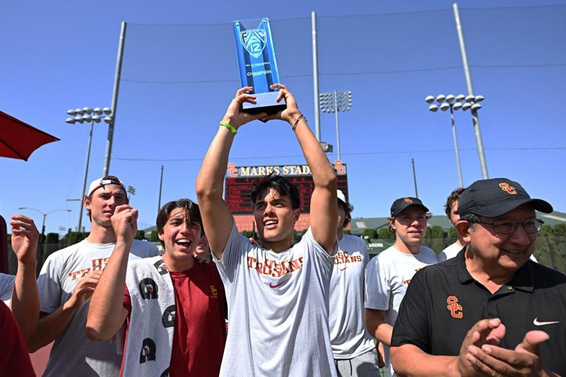 The men's tennis team celebrating their win with their trophy.
