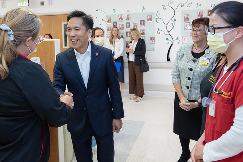 USC Interim President Kim shaking a Keck caregivers hand