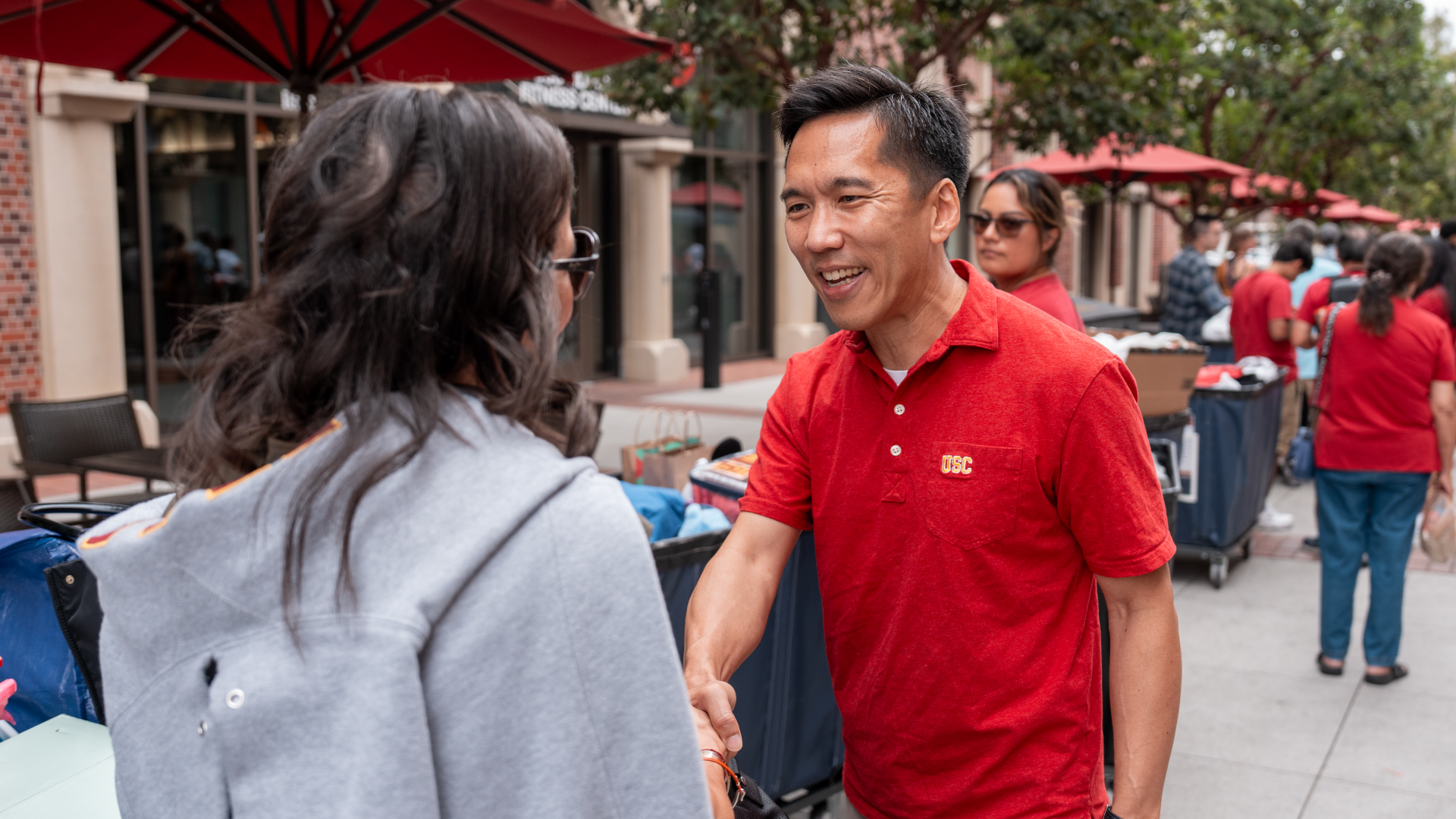 USC President Beong Soo-Kim shakes hands with a student moving into USC Village.